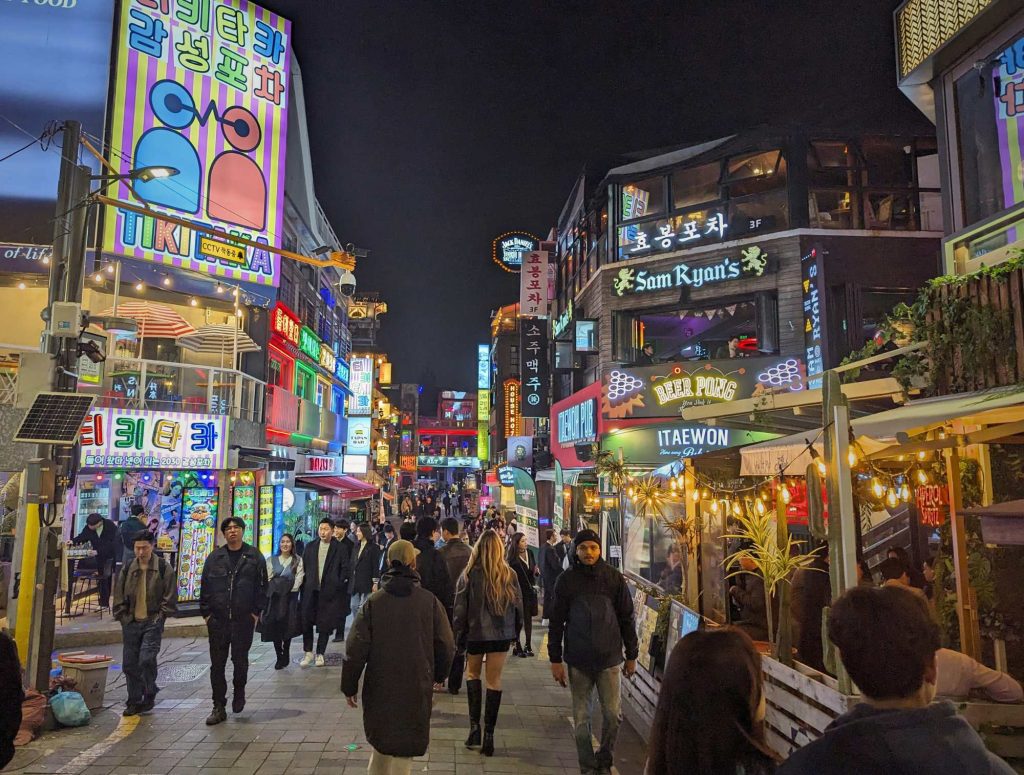 colourful street view of Itaewon with people walking